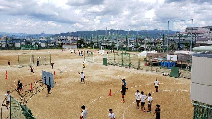 7月26 日(金)夏休み3日目、午前中のグラウンドでは、陸上部、野球部、男女各ハンドボール部、男子硬式テニス部、女子ソフトテニス部が部活中。