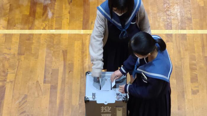 11月29日(火)2年生が政治的教養を育む教育の一環で体育館で「模擬投票」を実施