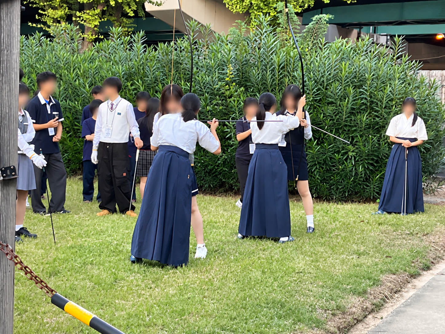 屋外で弓道を練習する学生たち.png